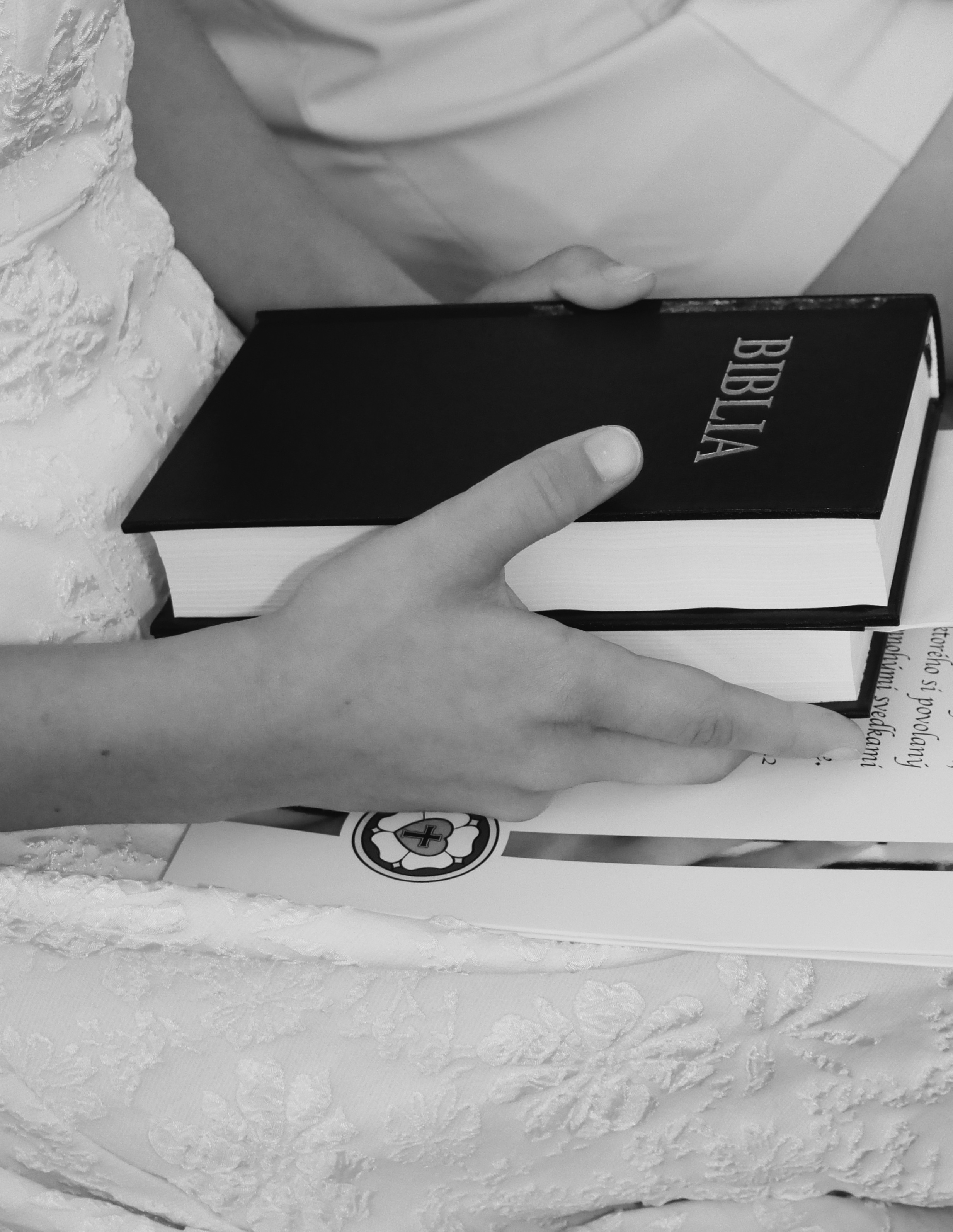 Detail — konfirmand drží Bibliu počas obradu
